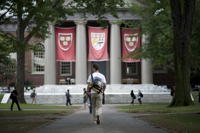 Harvard University students walk the school’s campus in Cambridge, Mass.